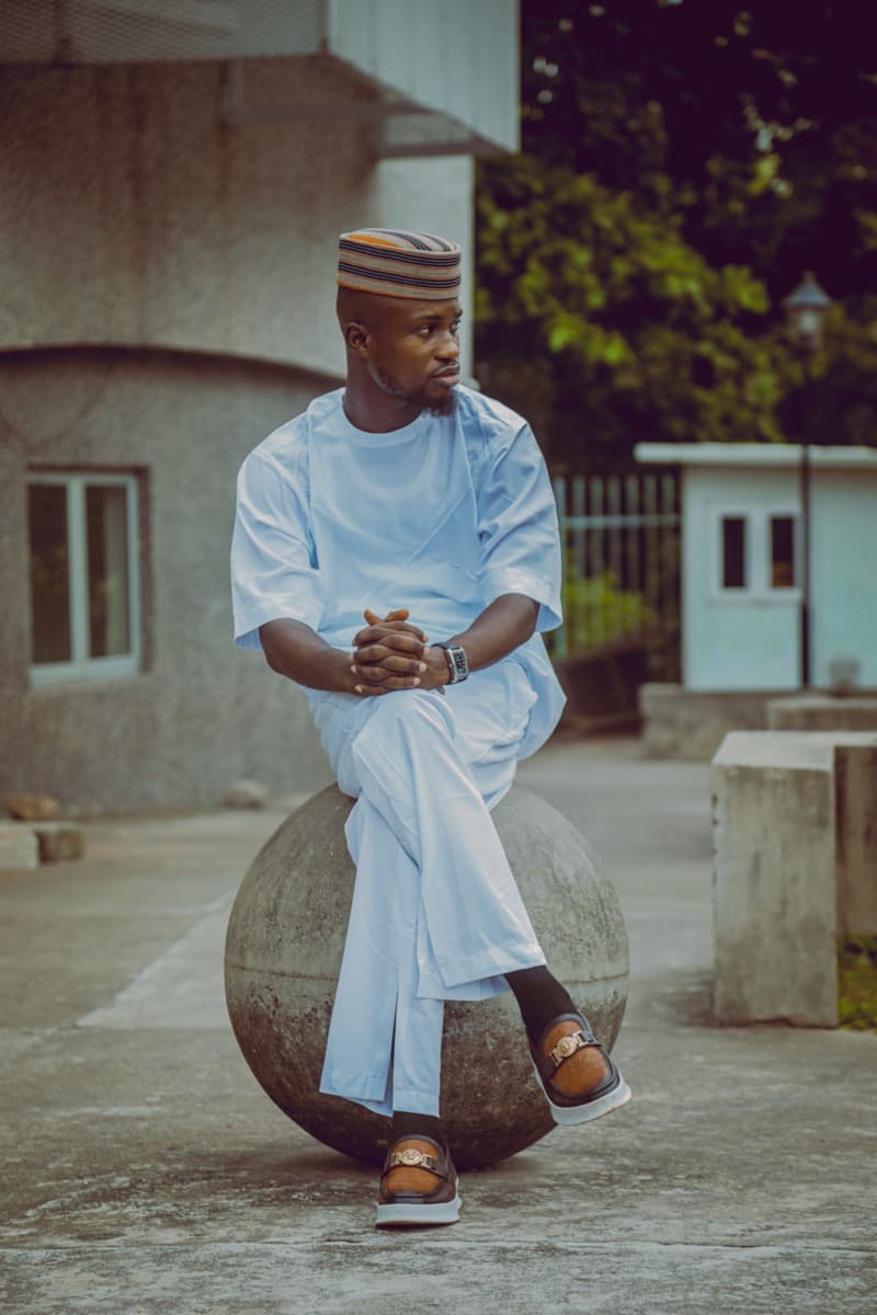 A man in a slim-fit cream senator wear outfit with wide-leg trousers