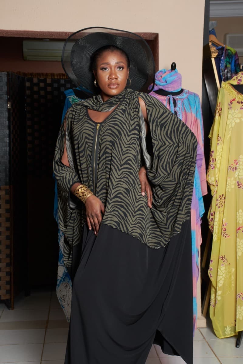 A woman in an oversized olive and black zebra-print draped top worn over a separate black skirt